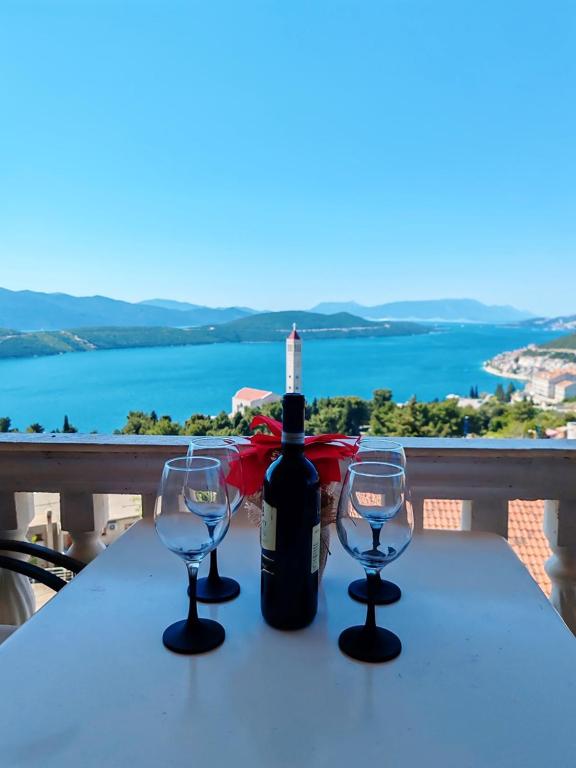 a bottle of wine sitting on a table with two glasses at Apartment & Rooms Tempera in Neum