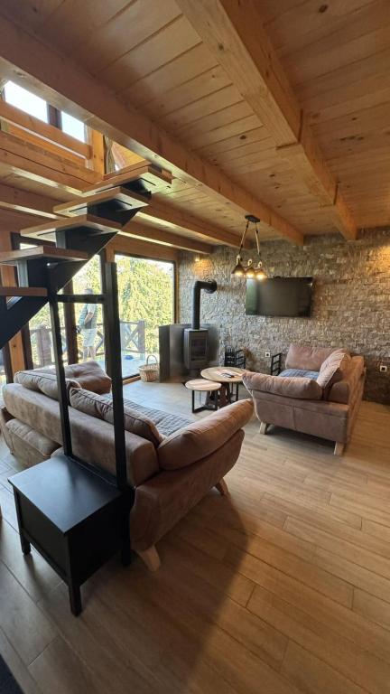 a living room with a large couch and a table at Brvnare Libero TARA in Bajina Bašta