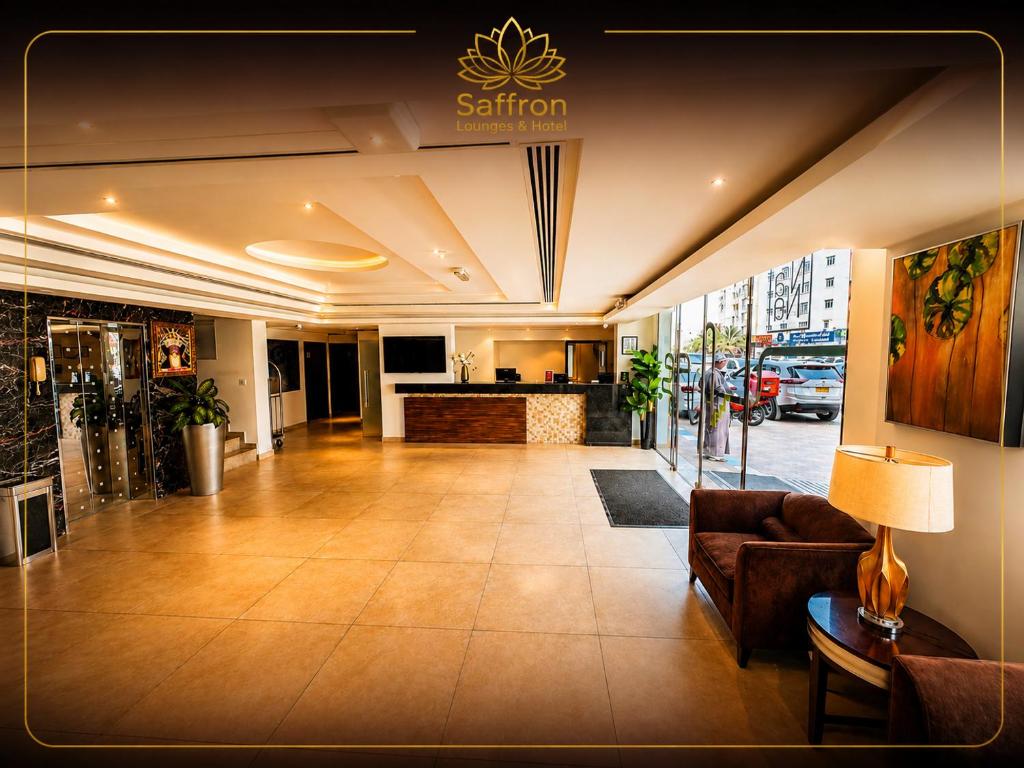 a lobby of a hotel with a couch and a counter at Saffron Hotel and Lounges in Muscat