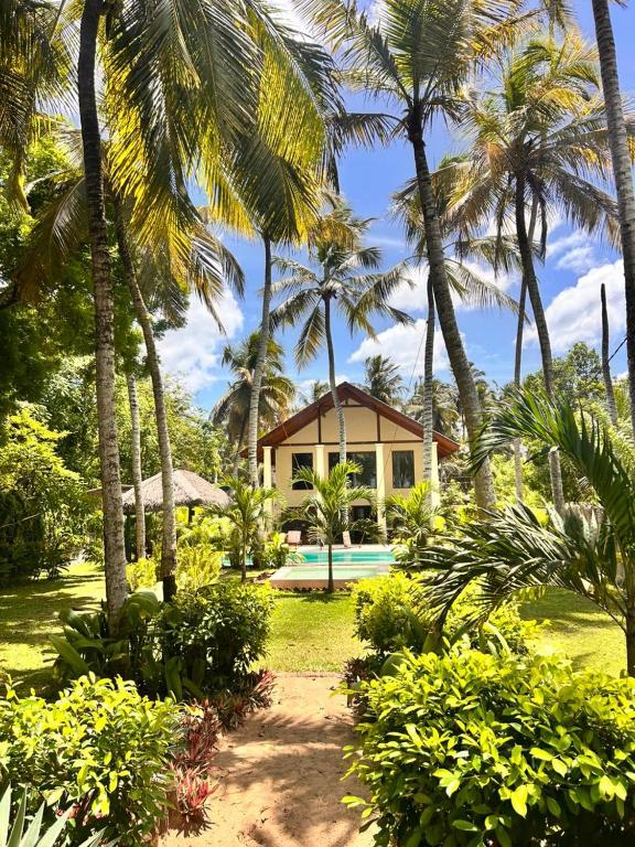a house with palm trees and a swimming pool at Ocean Divine Villa in Kalametiya