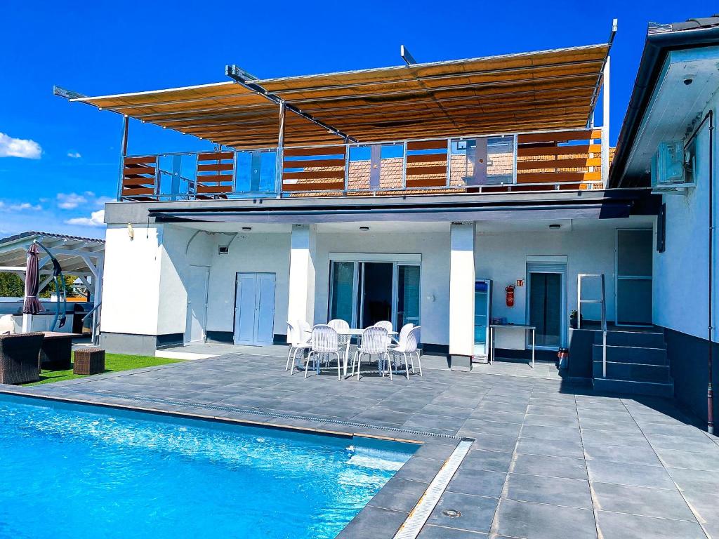 a house with a swimming pool next to a house at Banova Vendégház in Császártöltés
