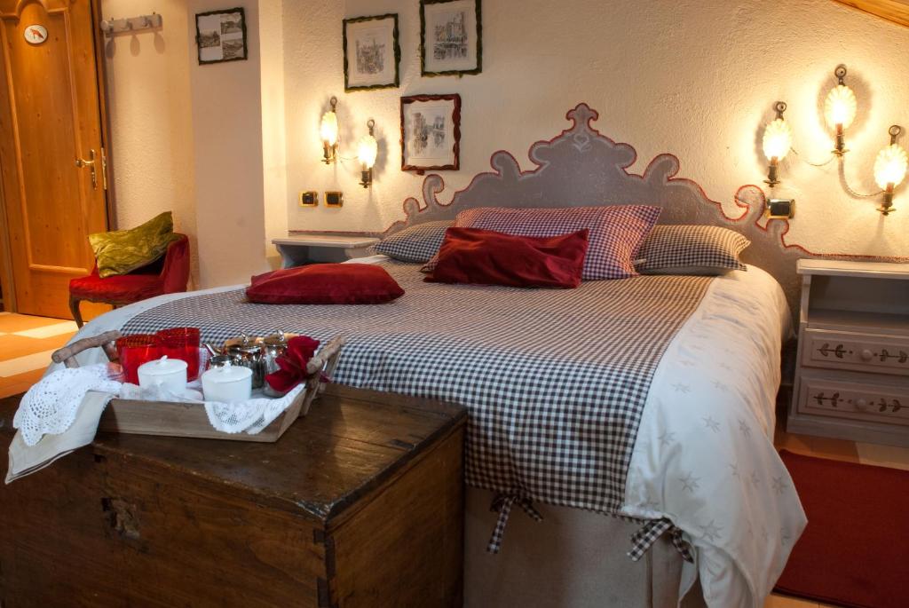 a bedroom with a large bed with red pillows at Hotel PIAN DEL SOLE Claviere in Claviere