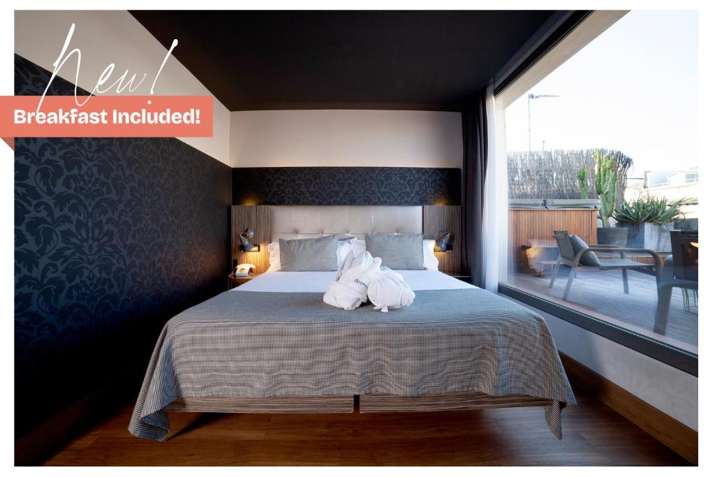 a bedroom with a bed with two towels on it at Petit Palace Museum in Barcelona