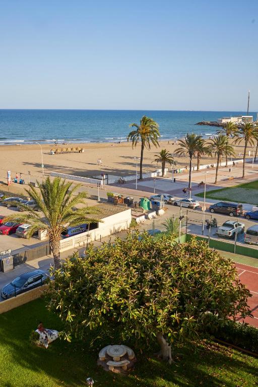 a view of a beach with palm trees and the ocean at Beachfront Apartment with Sea Views & Pool - El Puig in El Puig
