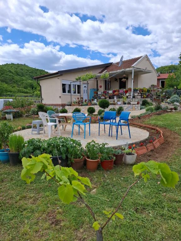 a house with blue chairs and a patio at Komani Hideout in Podgorica