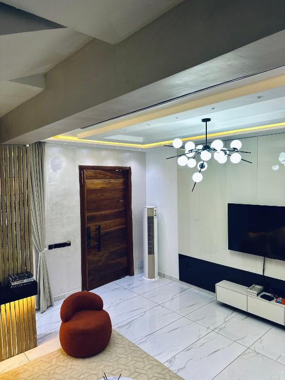 a large living room with a television and a chandelier at Diah Homes Apartment in Benin City