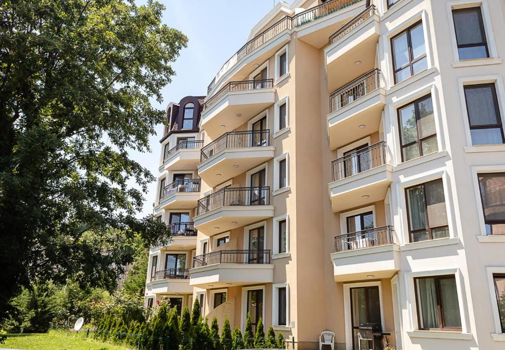 an apartment building with balconies and trees at Summer Apartments Kabakum by Flat Manаger in Golden Sands