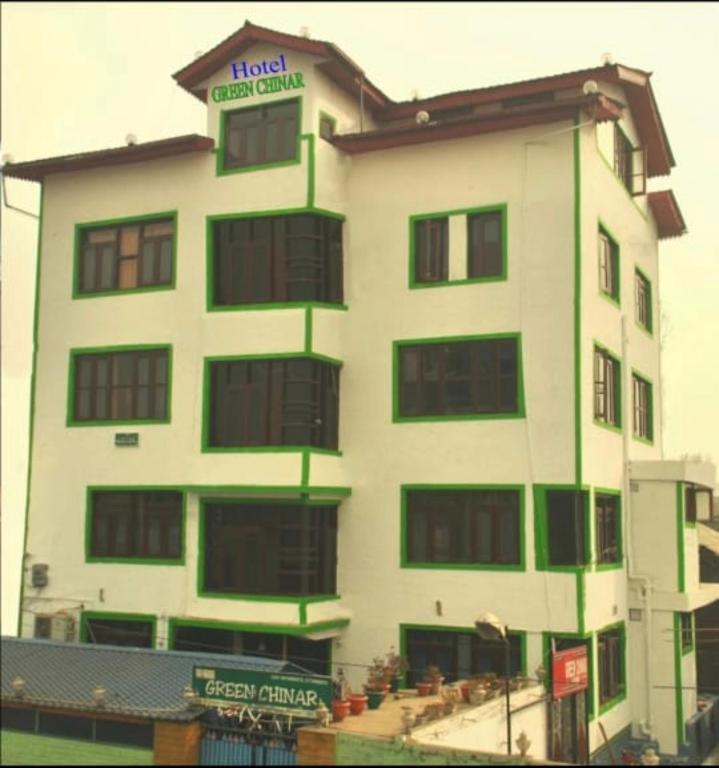 a large white building with a sign on it at Hotel green chinar & restaurant in Srinagar