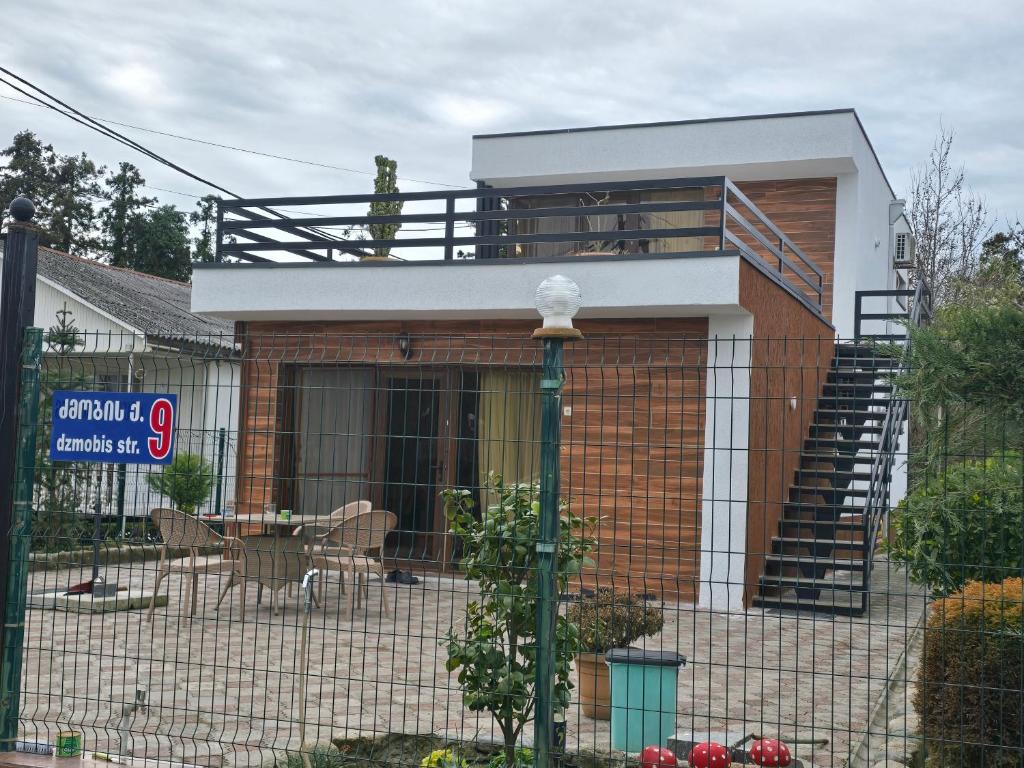 a small house with a balcony and a staircase at Dava&Davi in Ureki