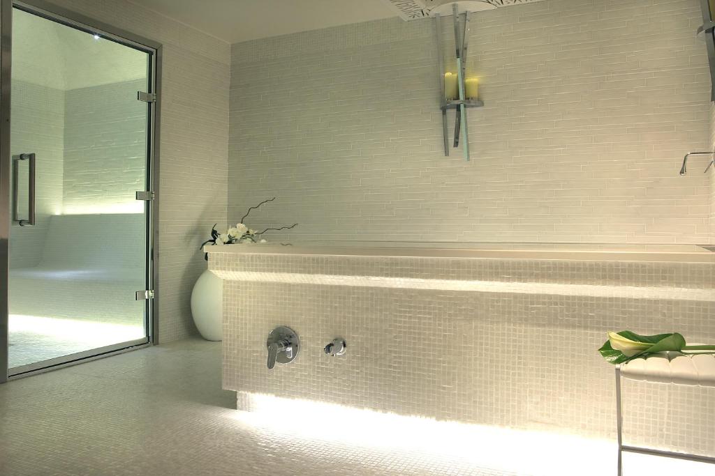 a bathroom with a tub and a sink and a mirror at Five Seas by Inwood Hotels in Cannes