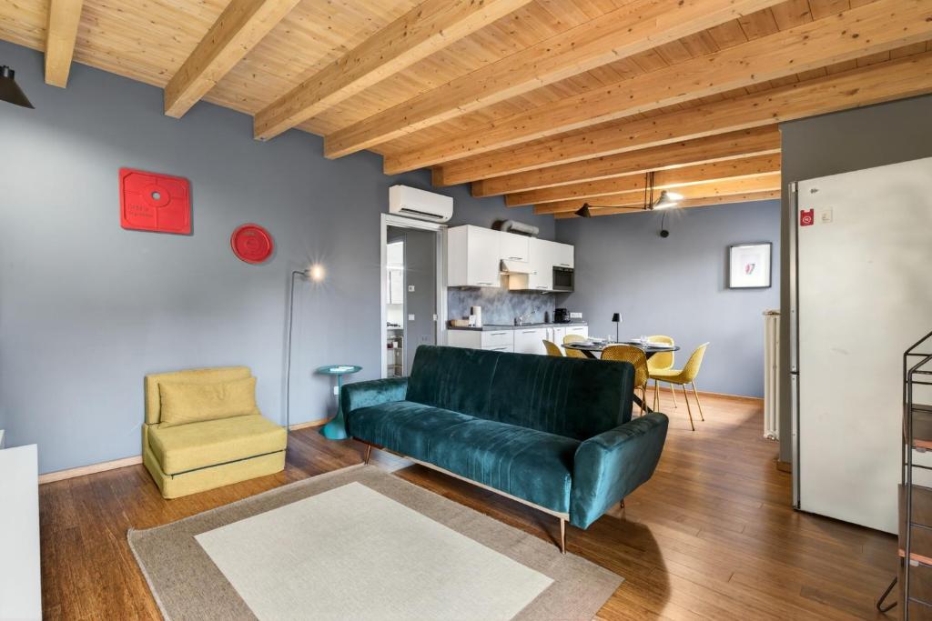 a living room with a green couch and a table at Lulli mansarda- 7Sundays in Milan