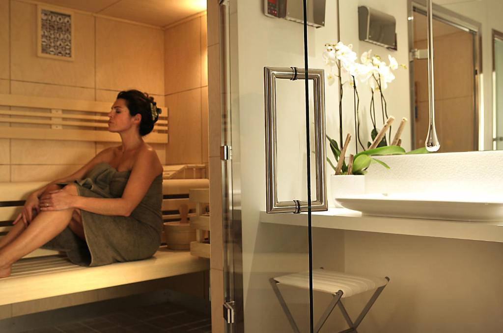 a woman sitting on a shelf in a bathroom at Five Seas by Inwood Hotels in Cannes