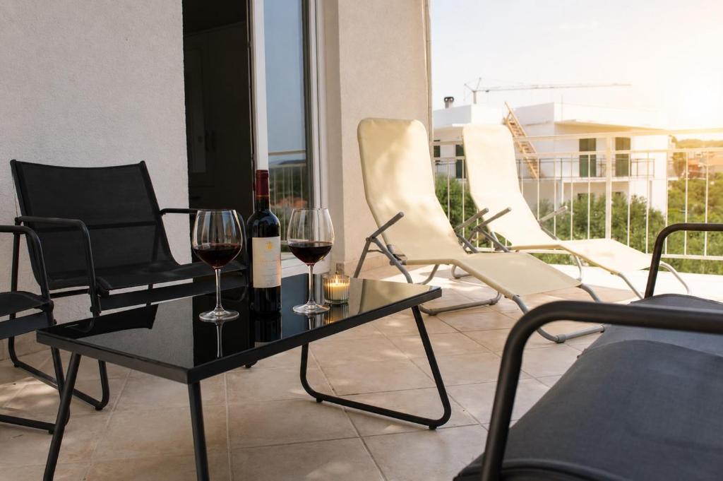 two glasses of wine on a table on a balcony at Apartment Nana in Primošten