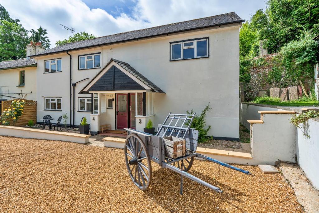 a house with a wagon in front of it at Finest Retreats - Poundtree in Wherwell