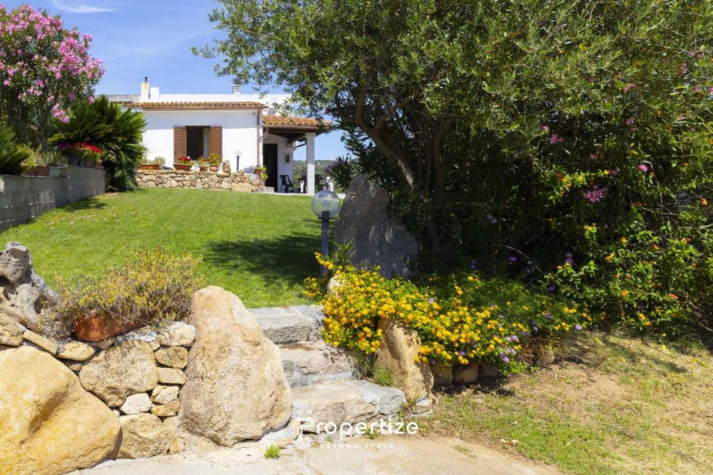 a house with a tree and flowers in a yard at Villa Rurale con Vista by Propertize in Monti