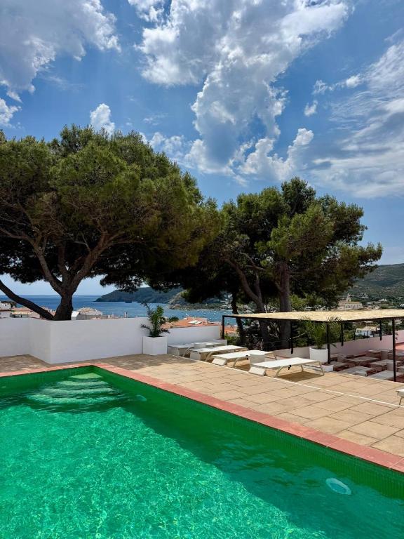 a swimming pool next to a patio with trees at Hotel Cadaqués1962 by Fimedhotels in Cadaqués