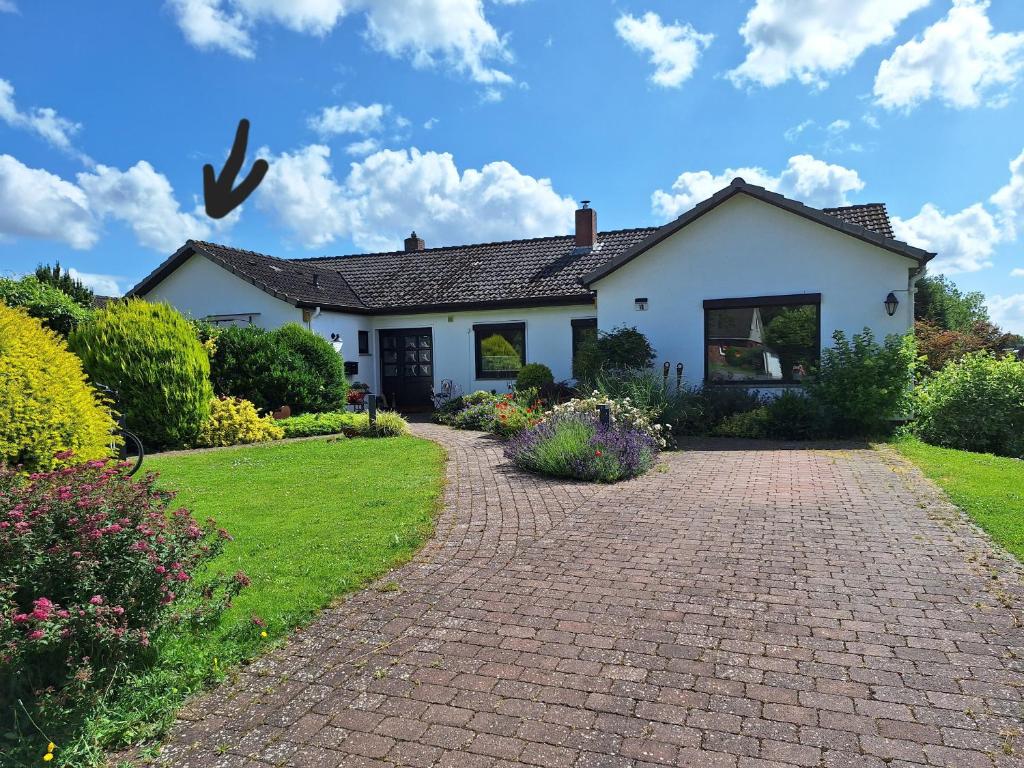 a white house with a brick driveway at "Schöne Auszeit" Ferienwohnung in Wiemersdorf