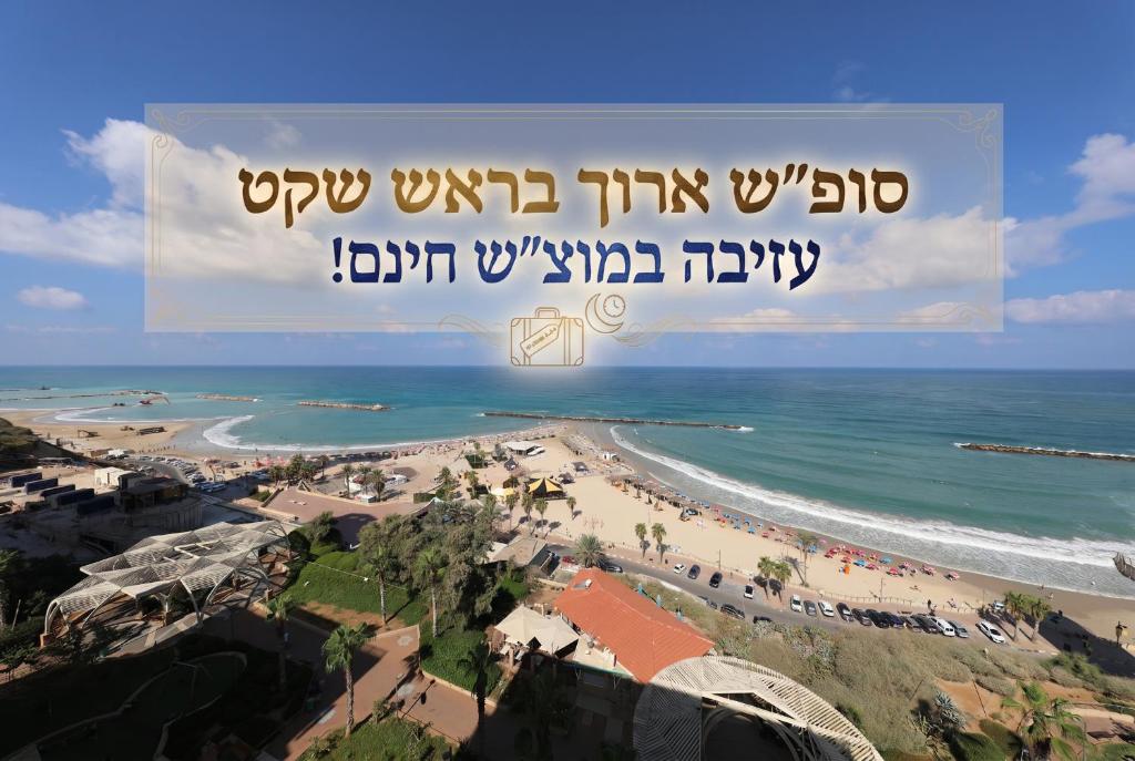 a view of a beach with a sign that reads upwell this wound at Residence Hotel in Netanya