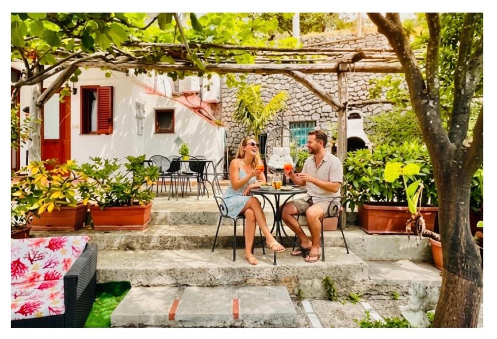 a man and woman sitting at a table on a patio at Il Rifugio Di Ela con 2 appartamenti in Furore