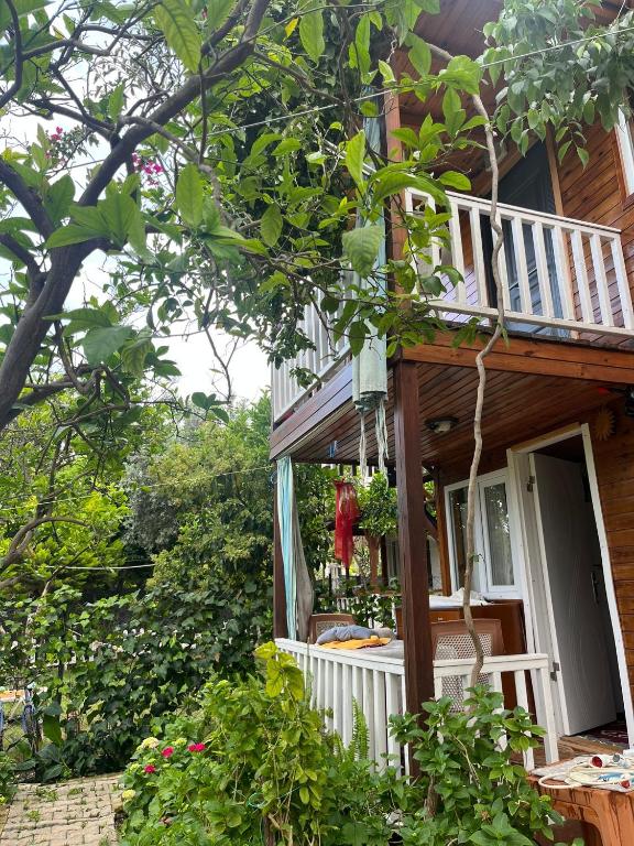 a wooden house with a porch and a balcony at Naz Apartlari Cirali in Cıralı