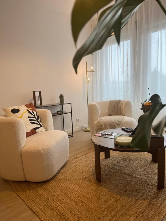 a living room with two chairs and a coffee table at Oh Activ Reims in Reims