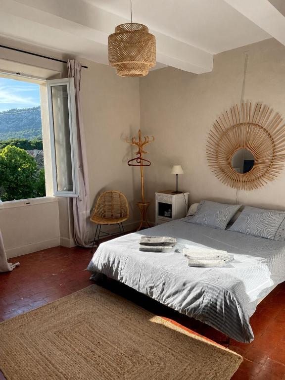 a bedroom with a bed and a large window at Mas Bérenger in Beaumes-de-Venise