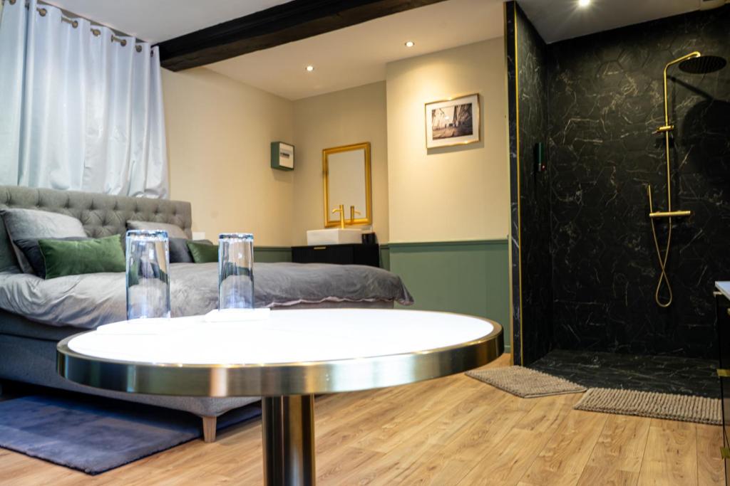 a living room with a table and a couch at La Suite Fernand Bar in Béthune