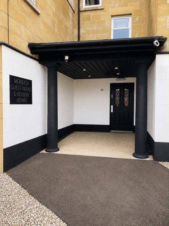 a entrance to a building with a black door at Morlich Guesthouse in Dingwall
