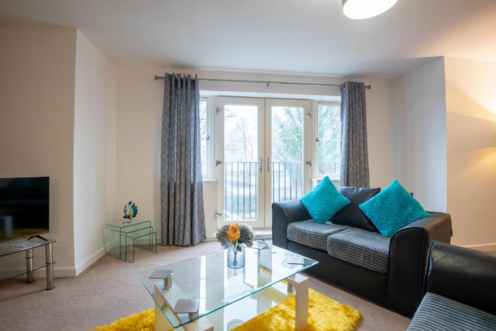 a living room with a couch and a glass table at No12, Modern 2 Bedroom Apartment in Mansfield