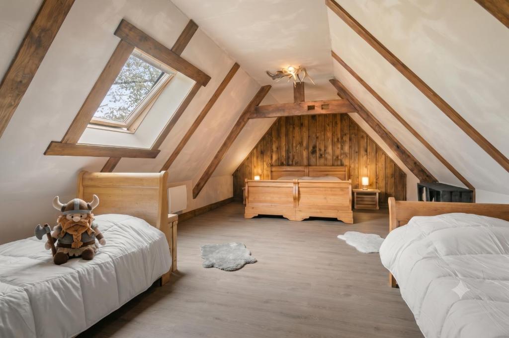 a attic bedroom with two beds and a window at Iaks keramik in Saumont-la-Poterie
