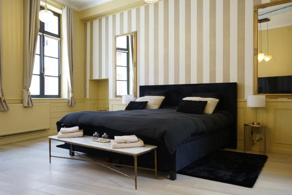 a bedroom with a large bed and a table at La suite Isabelle de Luxembourg in Béthune
