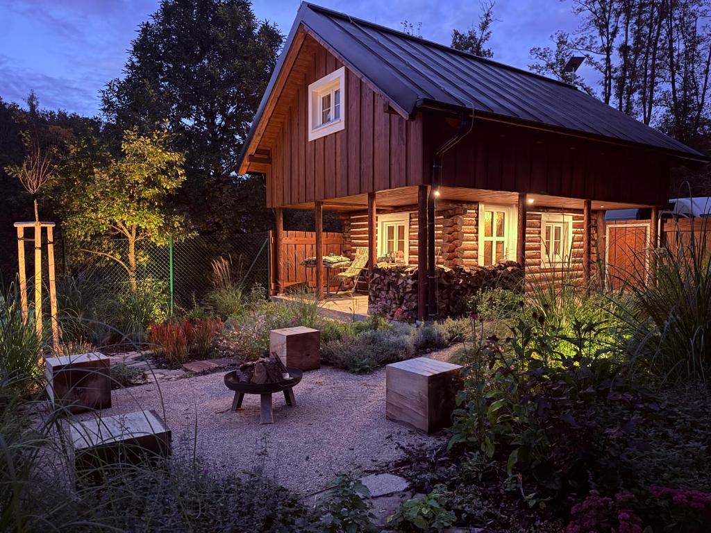a wooden house with a bench in front of it at Wellness Chata Trvalka in Píkovice