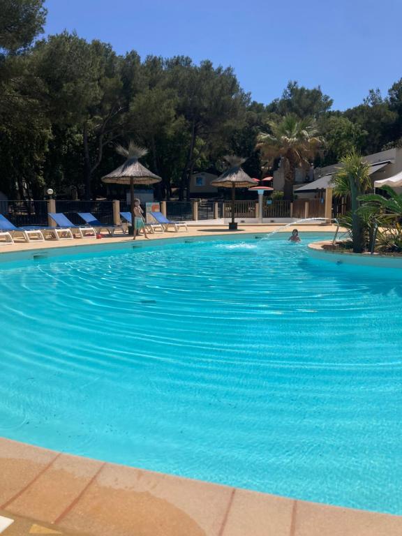 a large swimming pool with blue water in a resort at Camping Familial Buffalo Hacienda in La Seyne-sur-Mer