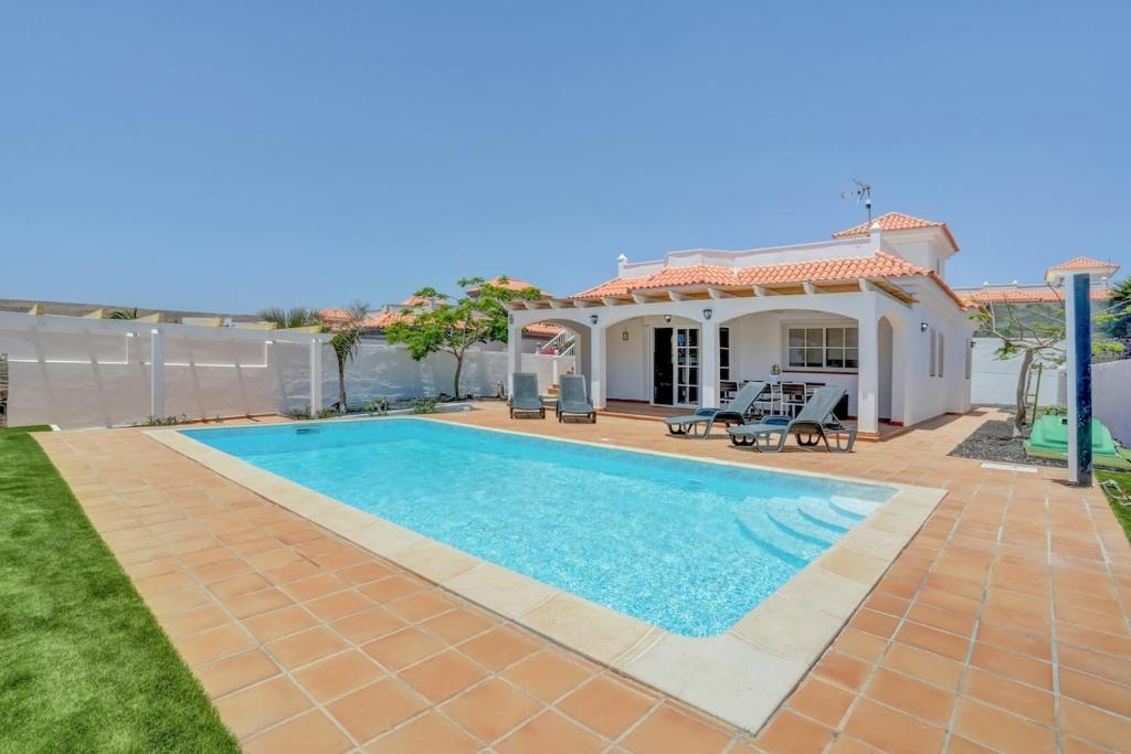 a swimming pool in front of a villa at Refugio del Viento in Antigua