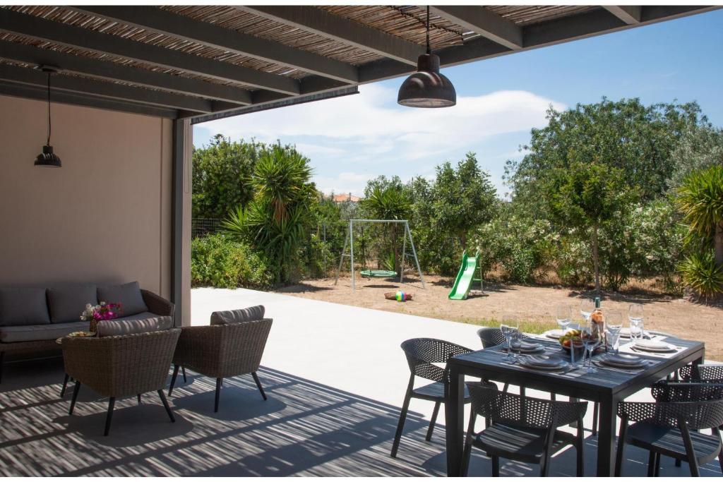 a patio with a table and chairs on a patio at Green & Purple in Khlóï