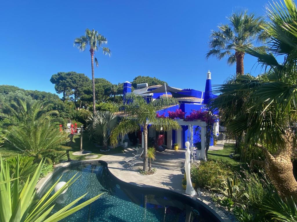 a resort with a swimming pool and palm trees at Villa Karolina in Quarteira