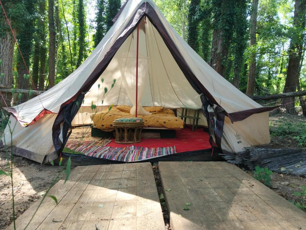 a teepee tent with a red rug in the woods at tente type yourth dans les bois in Saint-Paulet-de-Caisson