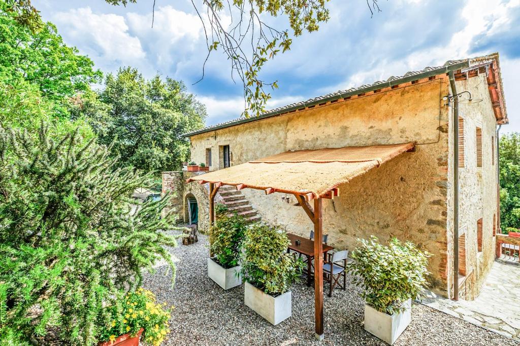 an outdoor patio with a table and an umbrella at Tenuta della Selva - Castellaccio 7 in Murlo