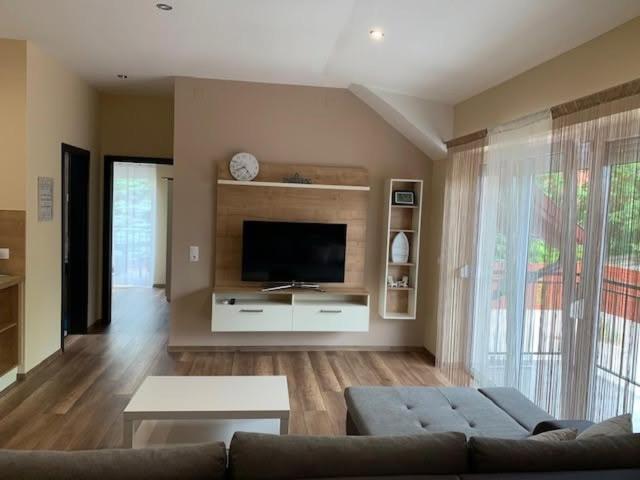 a living room with a couch and a flat screen tv at Felüdülő Apartman Balatonlelle in Balatonlelle