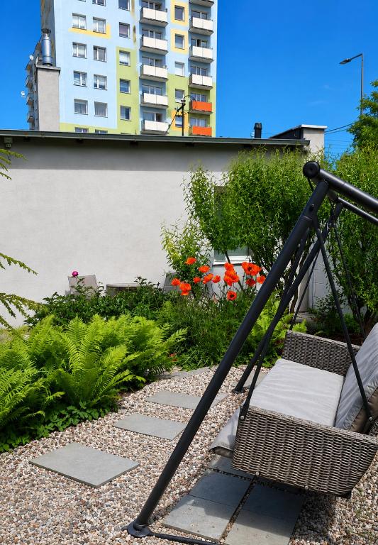 a swing in a garden with a building in the background at Fairy- tale house in Przeróbka in Gdańsk