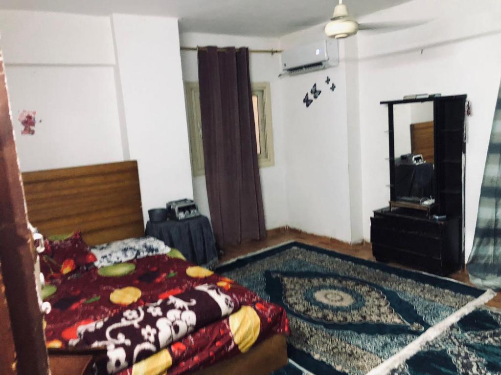 a bedroom with a bed and a mirror and a rug at مقاولين العرب in Cairo