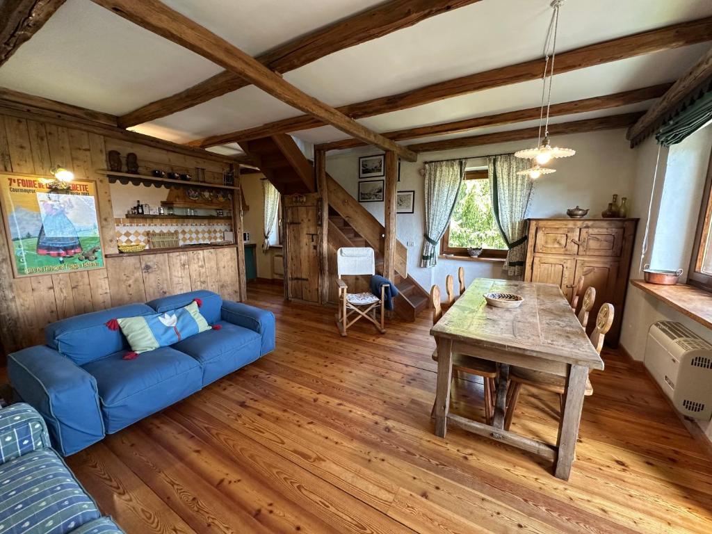 a living room with a blue couch and a table at Maison Angèle in Saint Nicolas