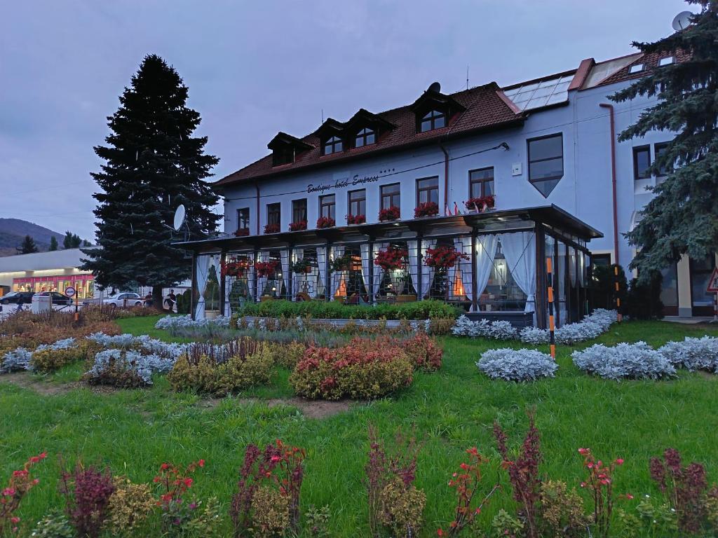 a large white building with flowers in front of it at Boutique Hotel Empress in Rožňava