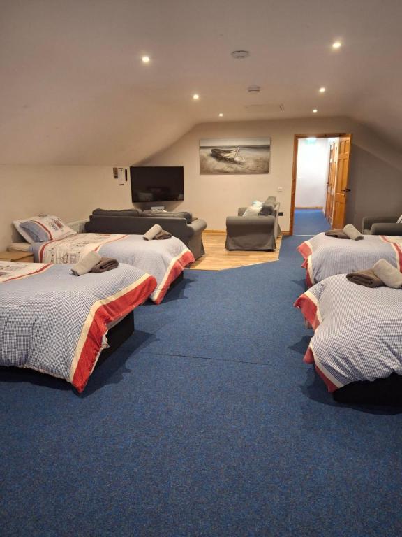 a room with four beds and a flat screen tv at Reubens Loft for 1 to 6 person Family 4 miles outside Portrush Bushmills Coleraine Ballymoney in Bushmills