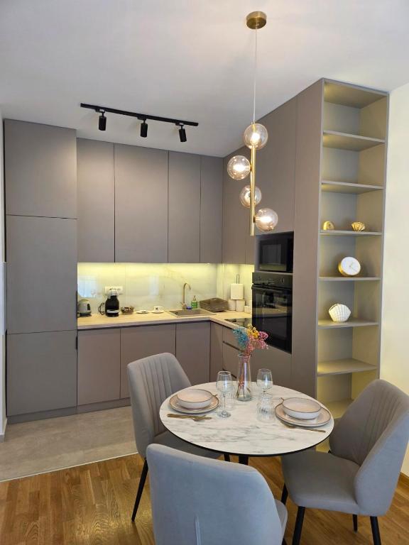 a kitchen with a table and chairs in a room at Gold Apartman in Pančevo