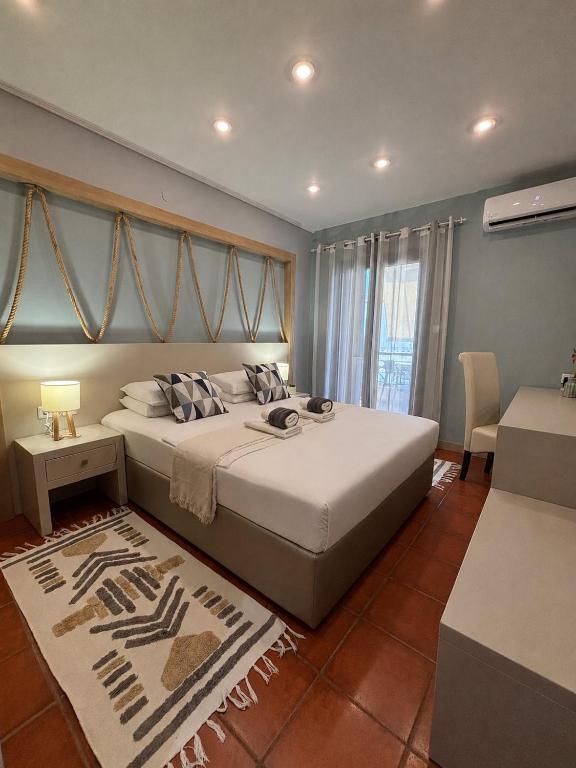a bedroom with a large white bed and a window at Green Suite Skiathos in Skiathos