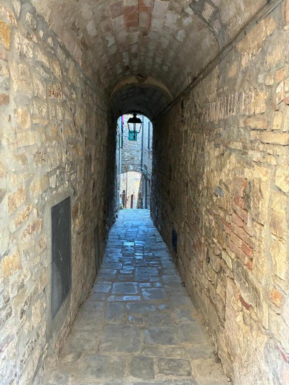 an alley in a stone building with a light at the end at Borgo Arte in Monteverdi Marittimo