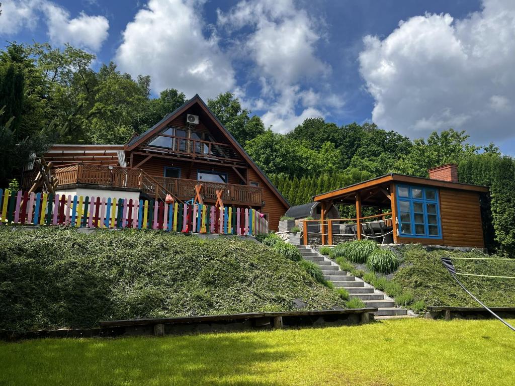 a wooden house with a fence in front of it at Sielski Domek Ręboszewo 94 in Ręboszewo