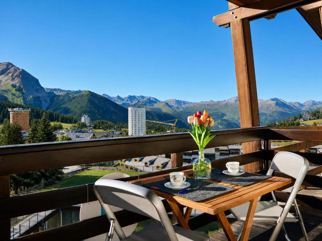 a table and chairs on a balcony with mountains at Hostdomus - Royal View in Sestriere