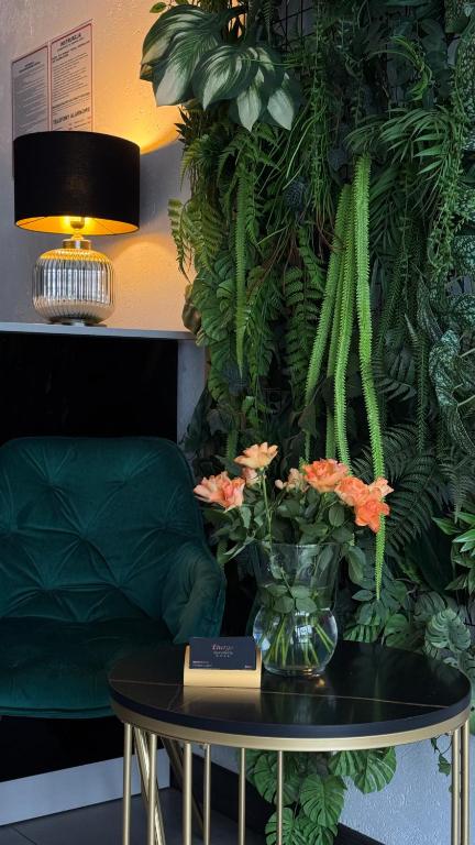 a table with a vase of flowers and a plant at Apartamenty Energo in Bytom